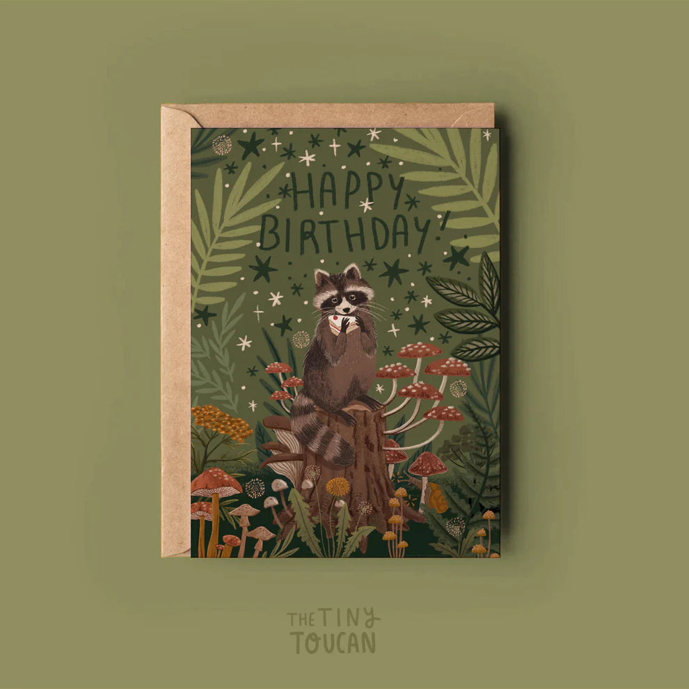 Birthday card with raccoon illustration and 'Happy Birthday!' text on a green background