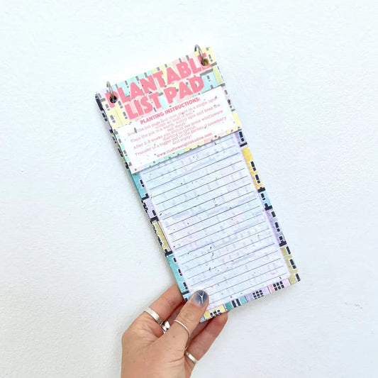 Hand holding a colorful notepad with a white background