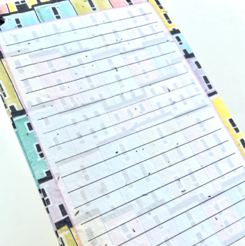 Close-up of a colorful notepad with lined pages on a white background