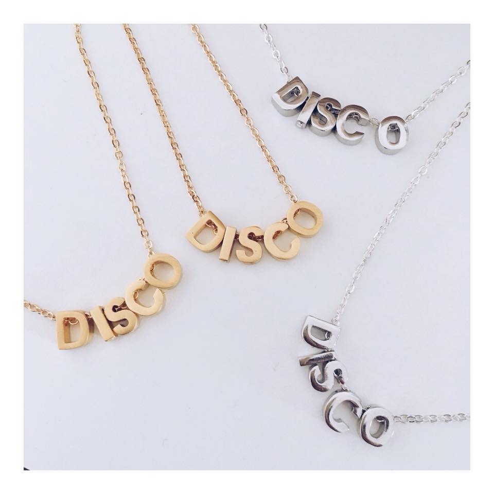 Three variations of a disco necklace with matt gold plated letters on adjustable chains.