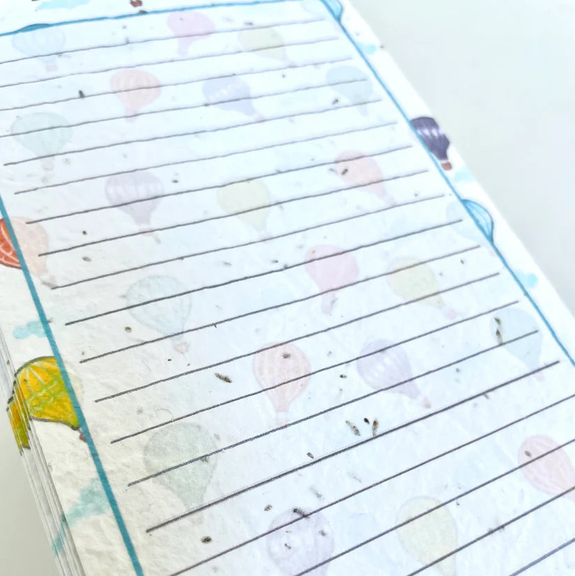 Notebook with lined pages and colorful illustrations on a white background